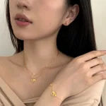 Világutazó ezüst nyaklánc repülővel és földgömbbel arany színben